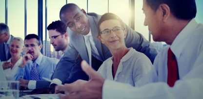 a group of business people sitting around a table.
