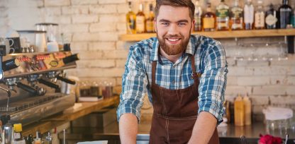 a man standing in front of a counter in a restaurant.
